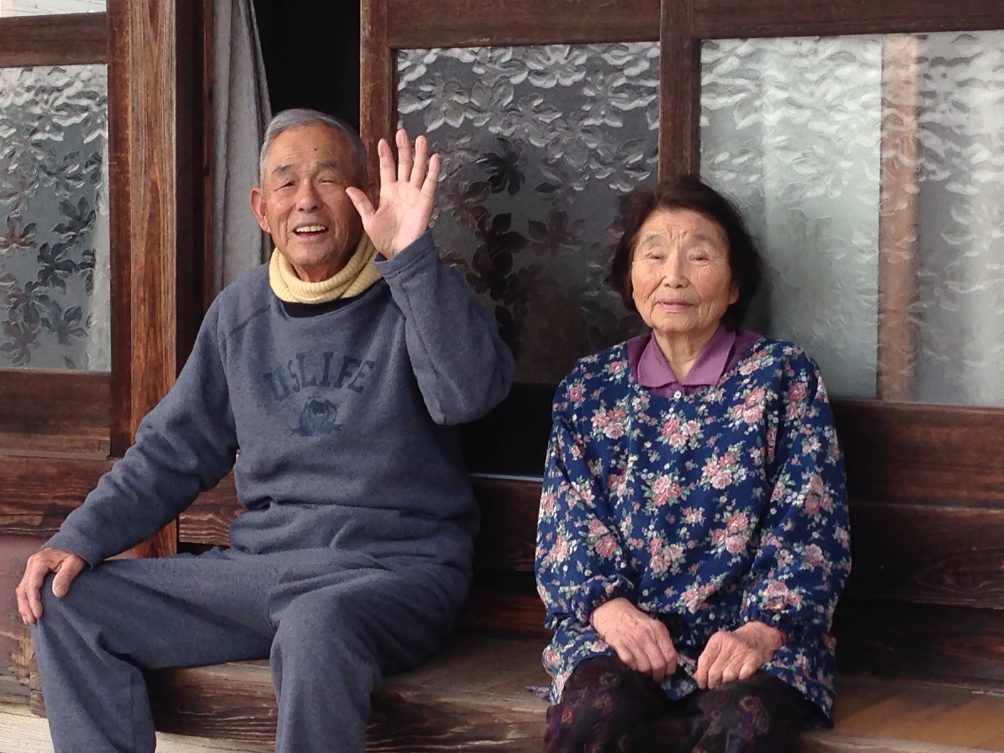 縁側で並んで座る高齢のご夫婦