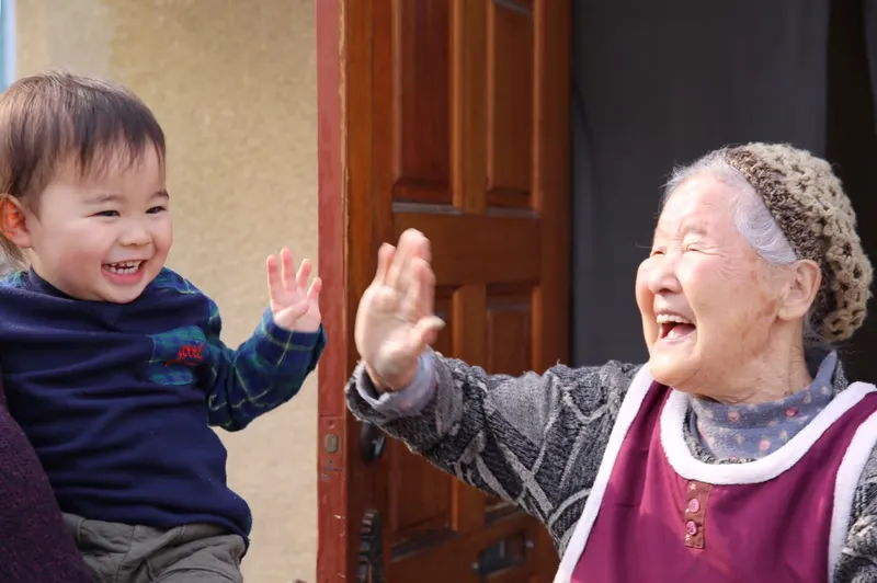 孫とハイタッチする祖母