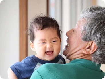 祖父に抱かれて笑う赤ちゃん