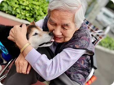 愛犬を抱きしめる高齢の女性