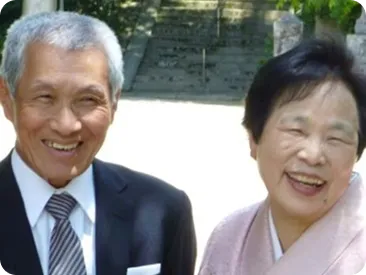 正装で並んで微笑むご夫婦