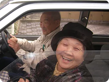 車の運転席と助手席で笑うご夫婦